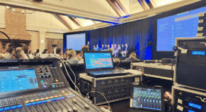 Advanced audio-visual control setup managing a live presentation, highlighting seamless coordination by a corporate event planner in Atlanta, CORPORATE CATERING & EVENTS.
